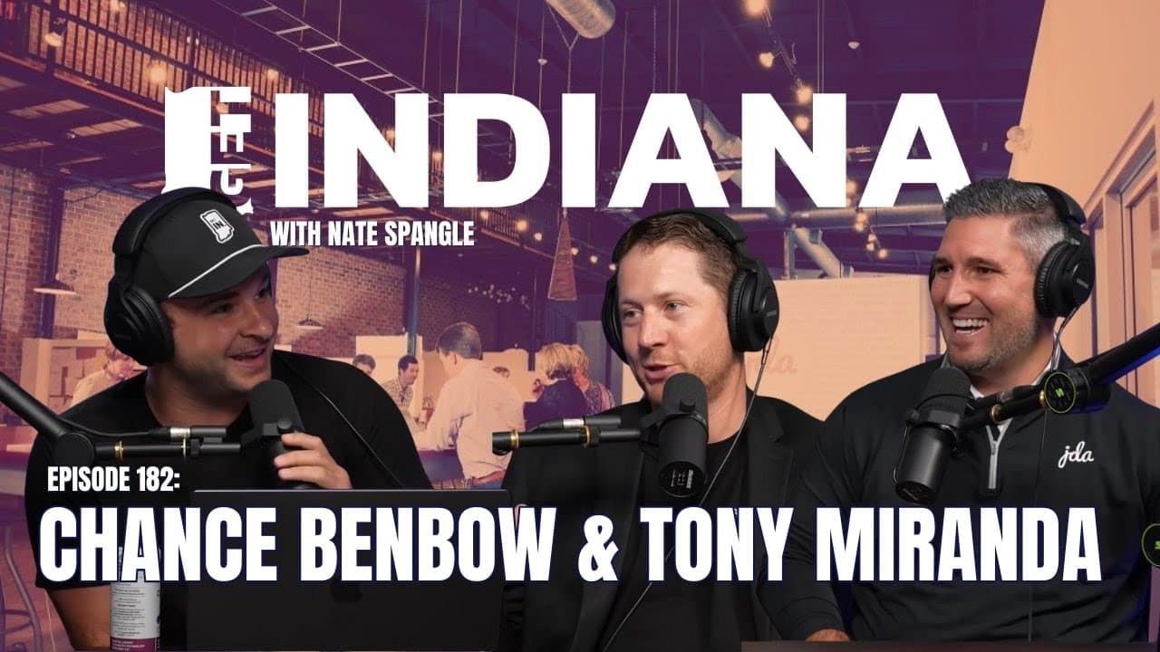 Three men in a modern podcast studio in Indiana, engaged in conversation with microphones and a lively background.